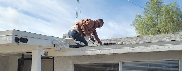 Roofworks technician performing a roof leak inspection and repair on a residential shingle roof.