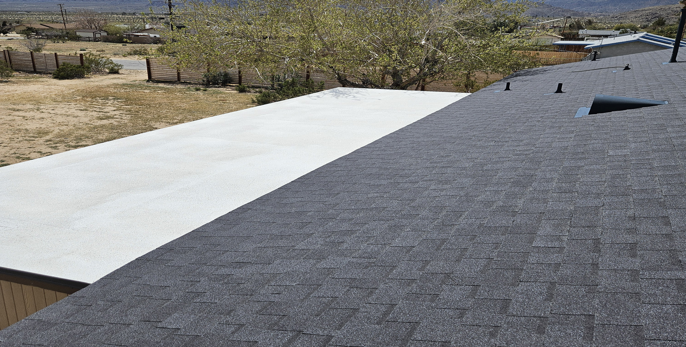Roofworks professional residential roof replacement featuring durable architectural shingles and flat roof section.